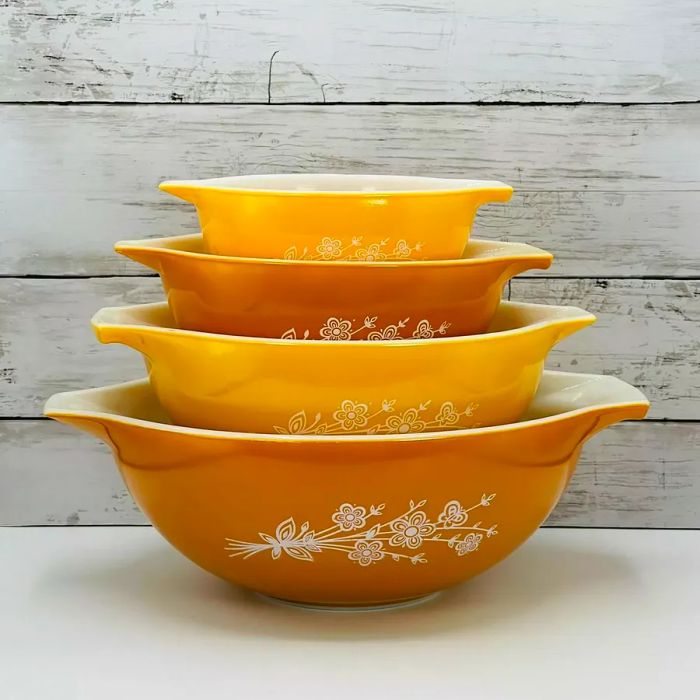 Mustard-colored nesting mixing bowls featuring a whimsical white floral design