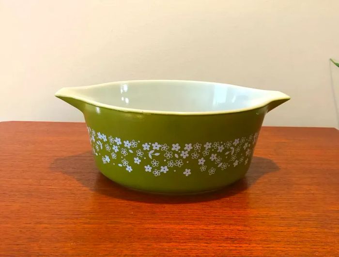 Vintage olive green casserole dish adorned with a delicate white floral pattern