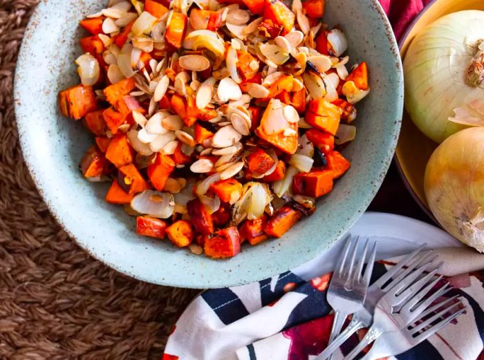 close-up shot of Roasted Sweet Potatoes & Onions with nuts in a bowl