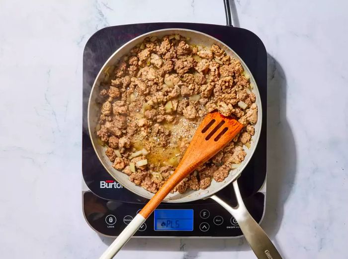 A large pan with browned, seasoned ground beef and pork.