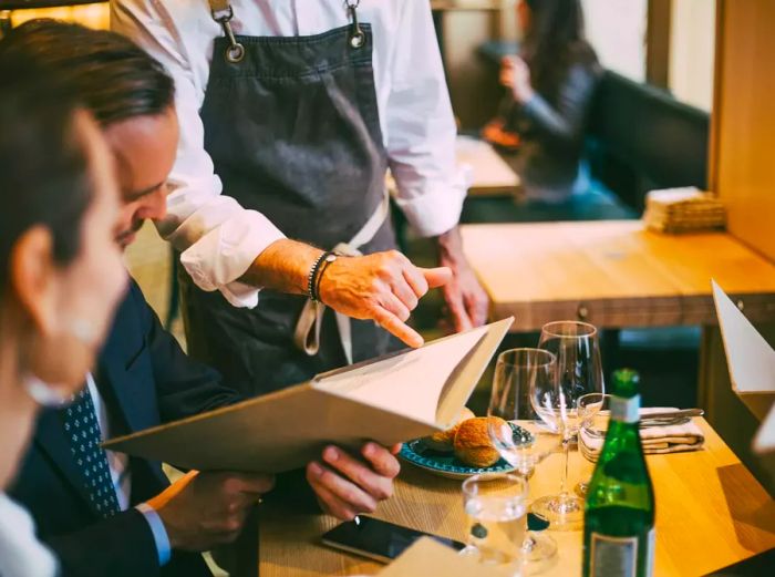 couple being guided by server to menu option