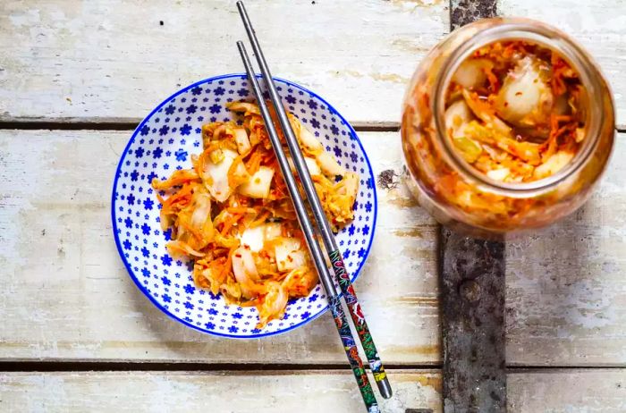 A bowl of homemade Korean kimchi made with Chinese cabbage, scallions, and carrots