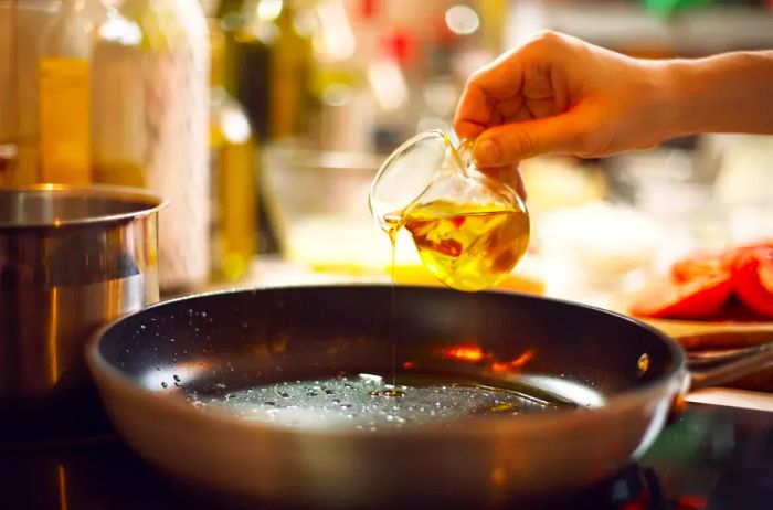 Pouring oil into a frying pan