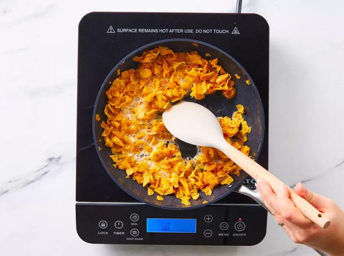 cornflakes sizzling in butter in a skillet