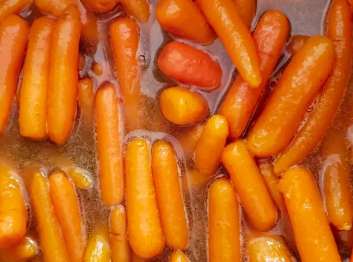 A close-up view of sweet baby carrots submerged in liquid.