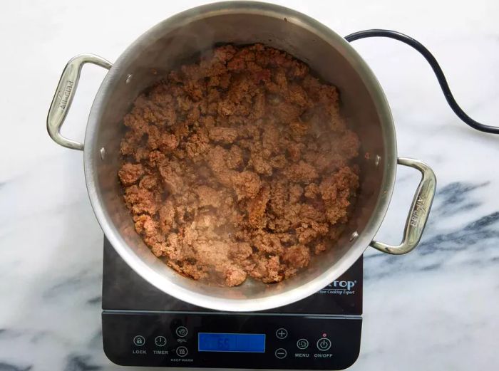 A large pot filled with browned ground beef