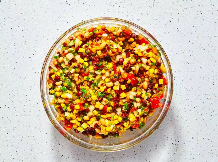 A bowl of cowboy caviar garnished with chopped cilantro on top.