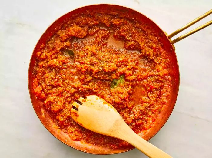 Stir chana masala gravy in the skillet with a wooden spoon