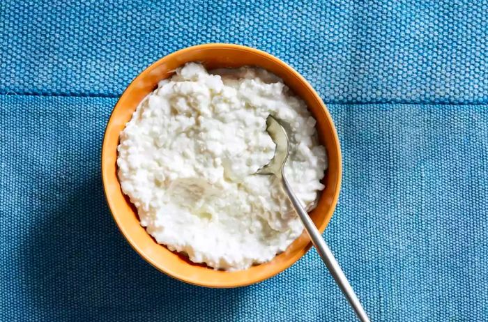 A bowl of cottage cheese placed on a blue placemat