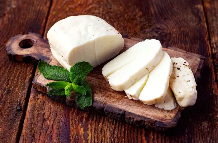 A wooden board with slices of halloumi cheese arranged neatly