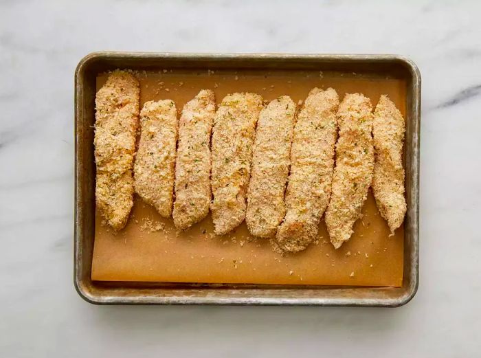 Breaded chicken strips arranged on the tray