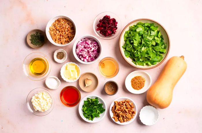 Bowls filled with the various ingredients needed to create the savory stuffed butternut squash.