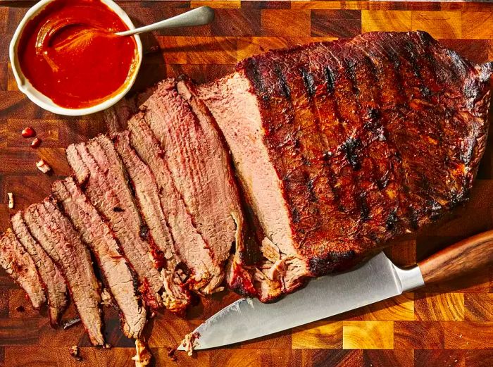 A close-up of a sliced beef brisket resting on a cutting board