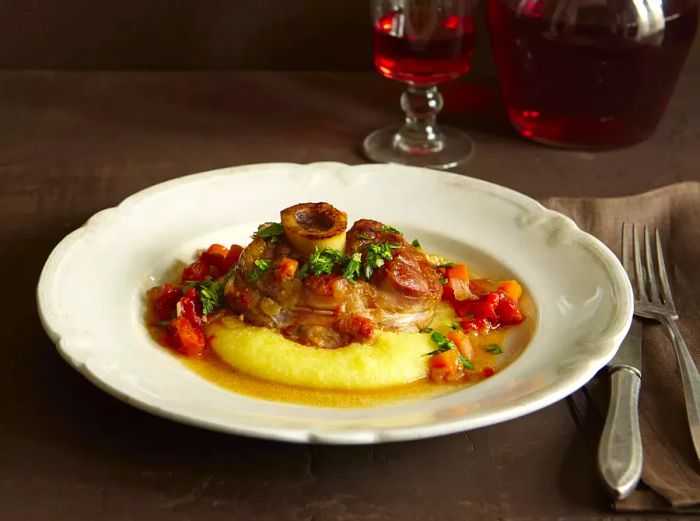 A close-up view of traditional osso buco served over polenta in a bowl