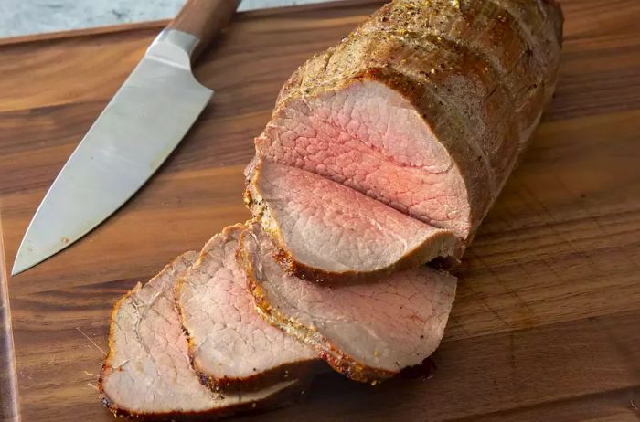 A high view of roast beef sliced on a cutting board