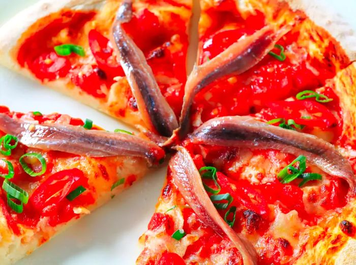 Pizza topped with anchovies and red pepper