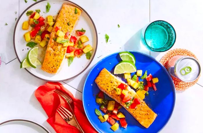 Salmon fillets served with a fresh pineapple and tomato salsa on top.