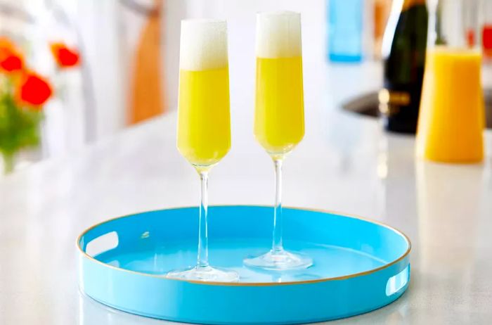 Two mimosas placed on a light blue tray