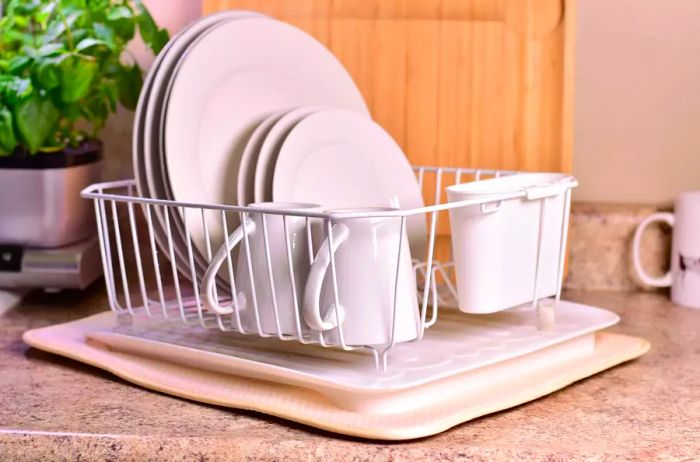 Beige Norpro dish drying mat placed under a rack of dishes