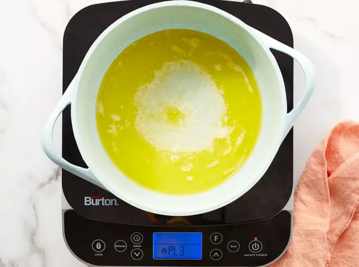 Aerial shot of water and butter simmering together in a pot.