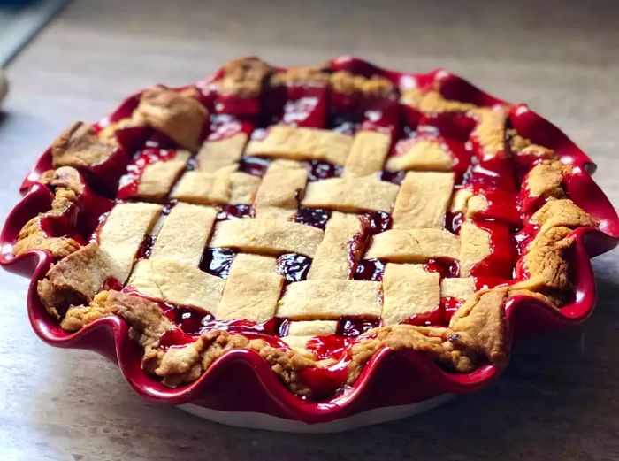 A delicious cherry pie served in a dish, showcasing the vibrant fruit filling