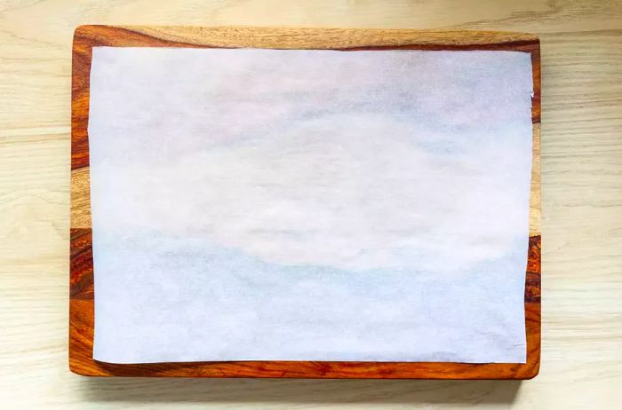 A rectangular piece of parchment paper on a cutting board