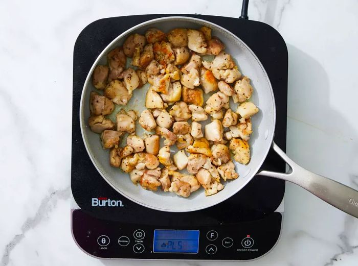 chicken searing in a skillet.