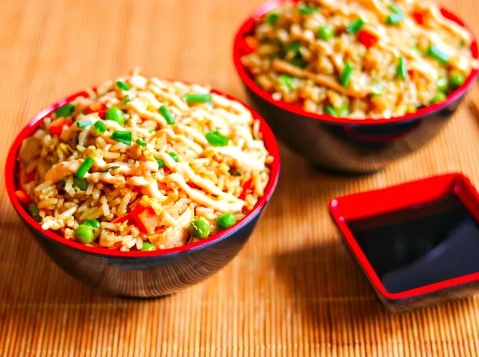 Traditional chicken fried rice served in Chinese bowls and garnished with scallions