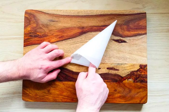 Double folding the edge of a parchment paper piping bag