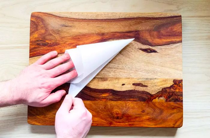 Shaping a parchment paper triangle into a piping bag