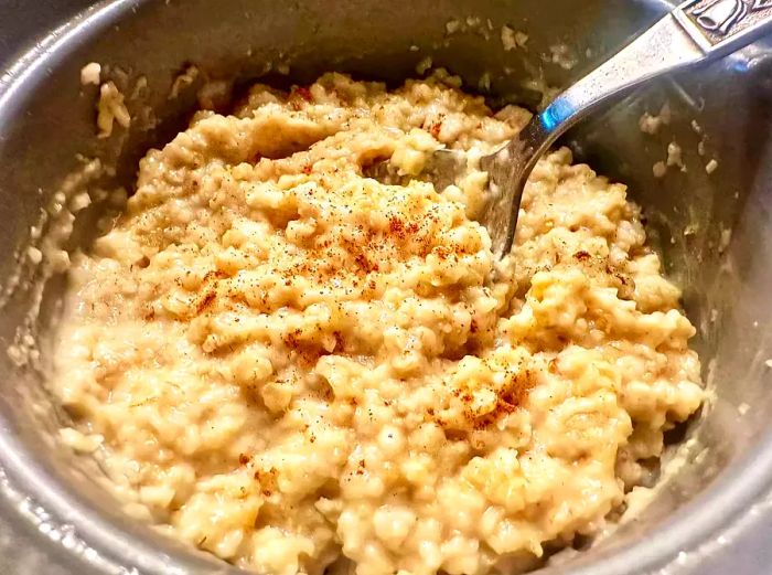 A bowl of rice cooker oatmeal, garnished with a sprinkle of cinnamon