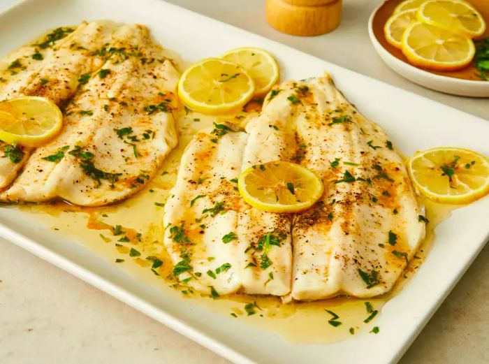 Close-up of several trout fillets topped with lemon slices