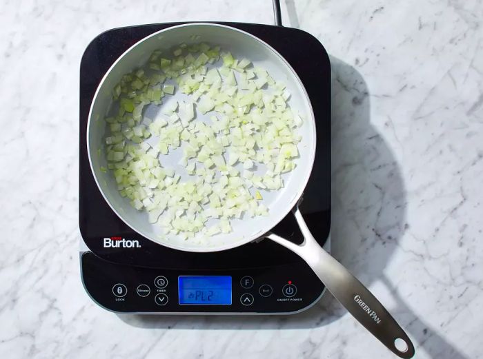 Onions cooking in a pan with hot oil.