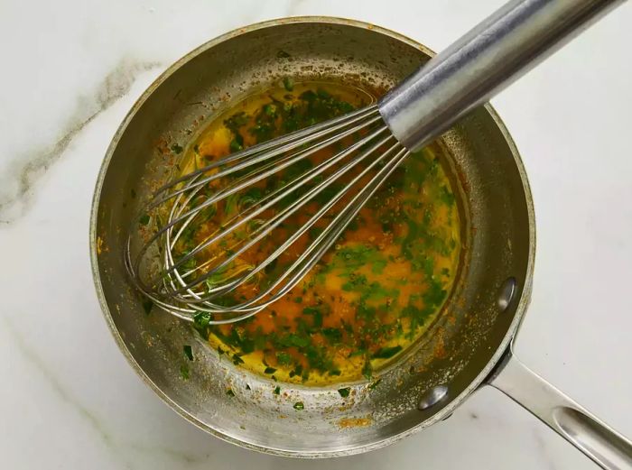 Melted butter, lemon juice, and parsley simmering in a saucepan