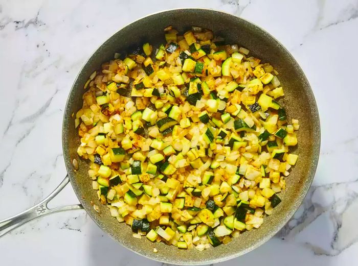 A skillet of sautéed zucchini and onions