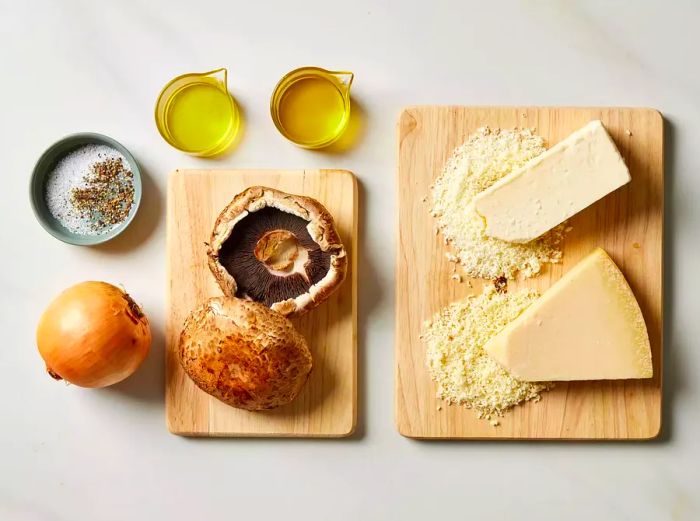 Portobello mushrooms, cheese, and oil neatly arranged on cutting boards.