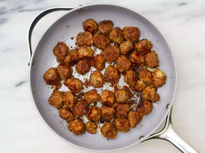 Aerial view of Swedish Meatballs (Svenska Köttbullar) cooking in a skillet.