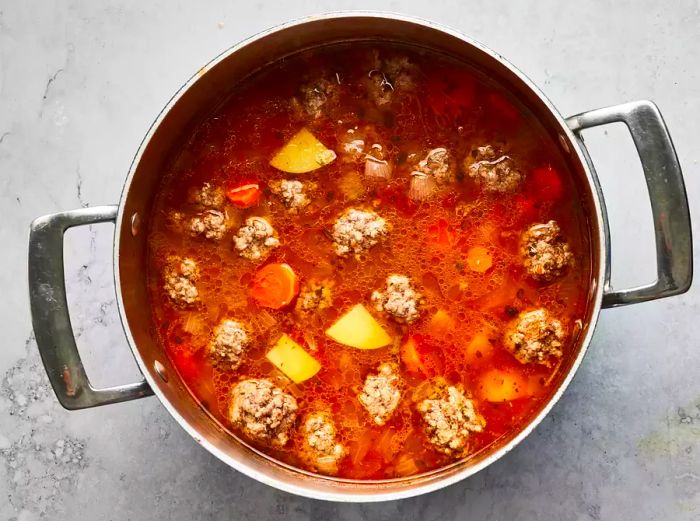 Aerial shot of albondigas soup simmering in a pot