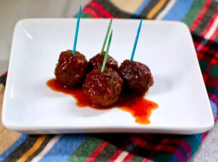 Glazed meatballs served with colorful toothpicks for a fun presentation