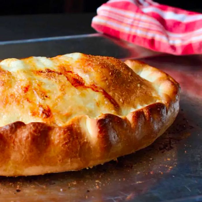 Close-up shot of a Ham and Cheese Calzone on a baking tray