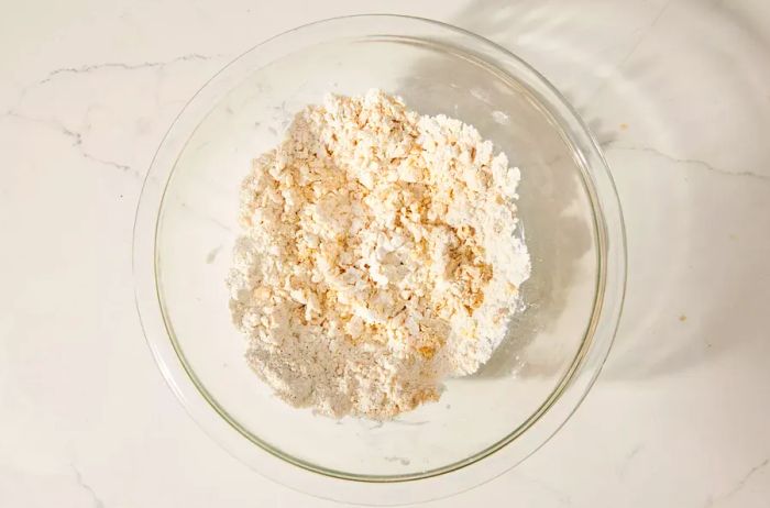 A bowl filled with a crumbly, seasoned flour and egg mixture