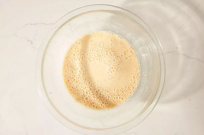 A glass bowl filled with beer batter