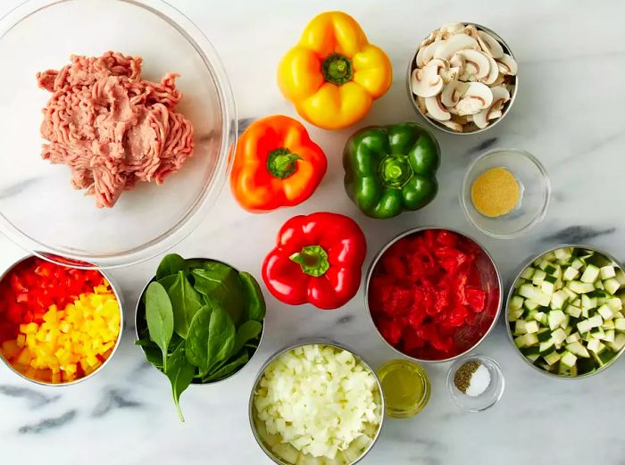 A top-down view of the ingredients prepared for stuffed peppers with turkey and vegetables.