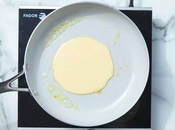 Pour 1/4 cup of batter into the greased skillet.