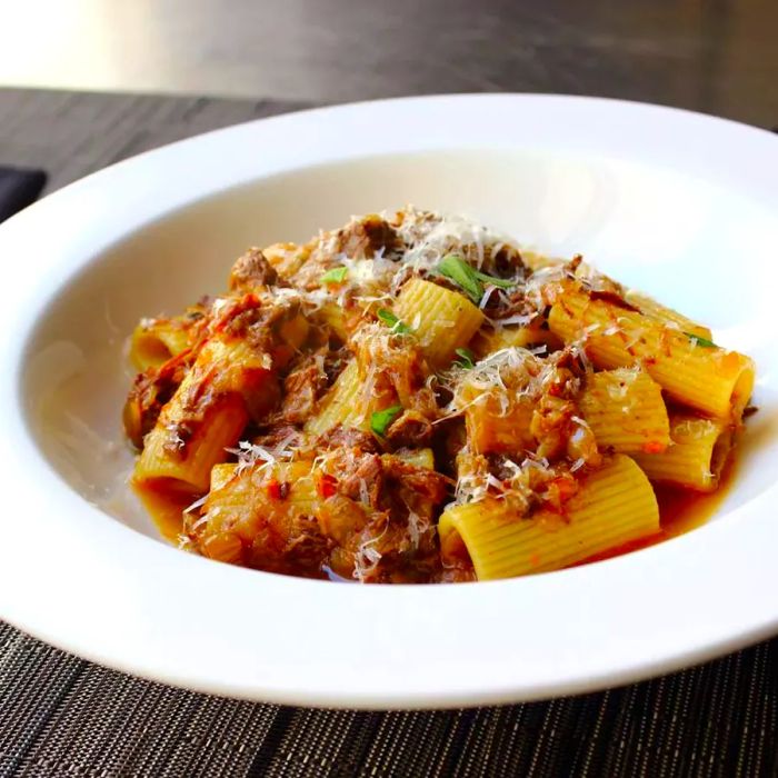 A close-up shot of Rigatoni alla Genovese served in a white bowl.