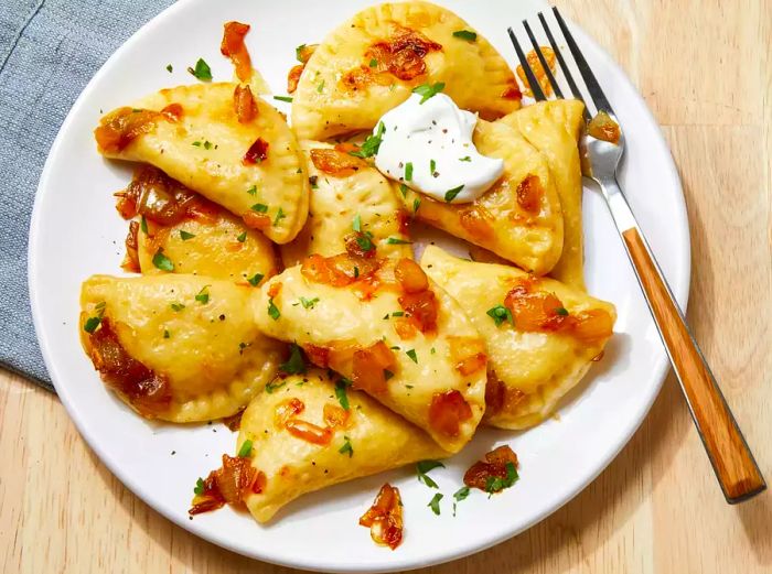 Gazing at a plate of pierogi, topped with a dollop of sour cream.