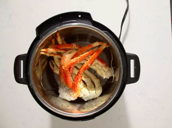 Aerial shot of crab legs placed in a pressure cooker.