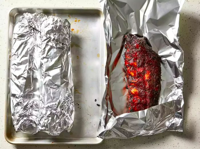 After the final basting, remove the ribs from the smoker and wrap them tightly in aluminum foil.