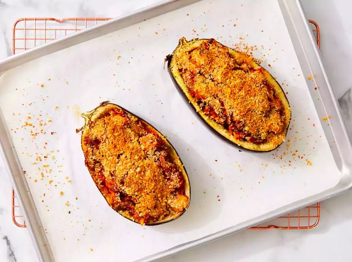 The stuffed eggplants, golden brown and perfectly baked, resting on a wire rack.