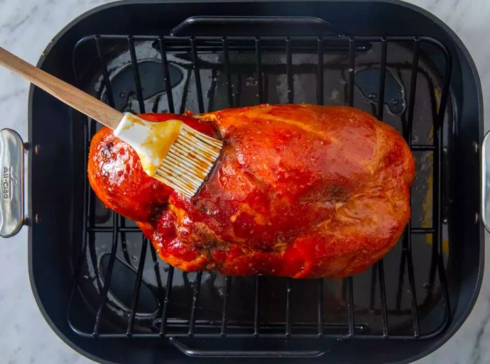 Brushing the glaze onto the ham